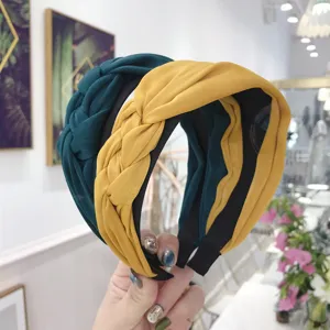 Wide braided fabric headband with handmade knot design in teal and yellow colors