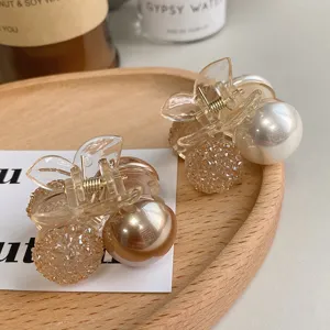 Detailed close-up of elegant cherry-shaped hair claws with pearls and crystals