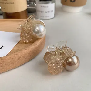 Close-up detail of elegant pearl cherry hair claw clips featuring crystal sphere designs
