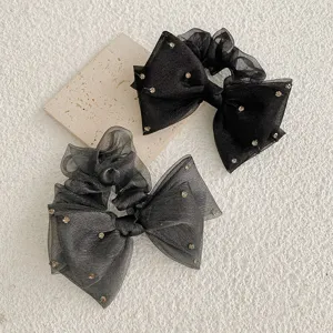 Vue détaillée de chouchous nœuds en organza élégants avec des accents de strass.