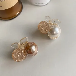 Close-up of cherry-shaped hair claw clips with faux pearls and crystals