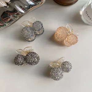 Detailed view of sparkling crystal cherry hair claw clips in four elegant color variants