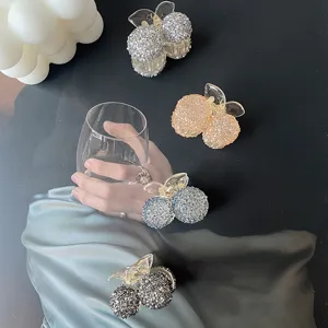 Detailed view of sparkling rhinestone cherry hair claw clips in various elegant colors