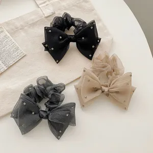 Vue détaillée de chouchous en organza avec de grands nœuds et des strass étincelants
