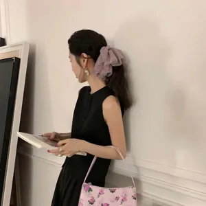 Model draagt een oversized paarse mesh kant scrunchie in een verfijnd zijprofiel aanzicht.