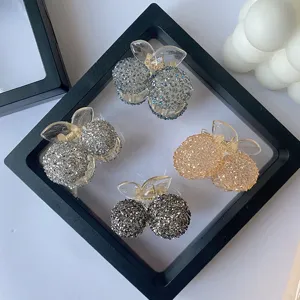 Group of sparkling cherry crystal mini hair claw clips displayed in a stylish frame