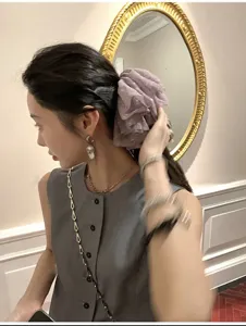 Detailweergave van een oversized paarse mesh scrunchie met subtiele stippen in het haar