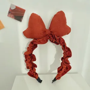Close-up detail of vintage red oversized suede bow headband with elegant ruffled design