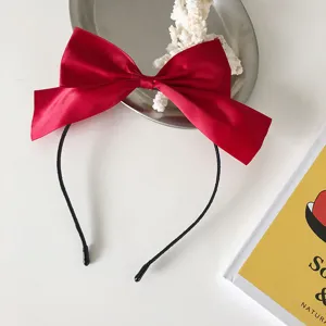 Elegant red satin bow headband for festive New Year and Christmas hair styling.