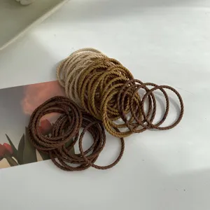 Detail shot of milk tea color elastic hair ties with a twisted rope texture design.