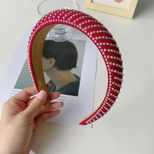 Detail of padded red headband with sparkling rhinestones and elegant curved design