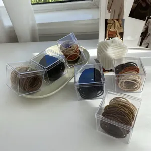Detailed macro view of milk tea color elastic hair ties sets presented in clear acrylic boxes