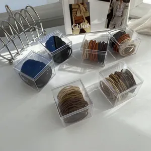 Detailed view of elastic hair tie sets in milk tea colors within clear acrylic boxes.