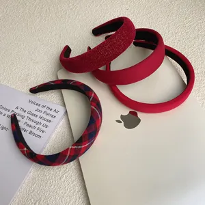 Detail view of thick red headbands in plaid, velvet, and smooth finishes