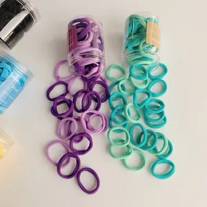Detail shot of colorful gradient elastic hair ties spilling from clear storage jars.