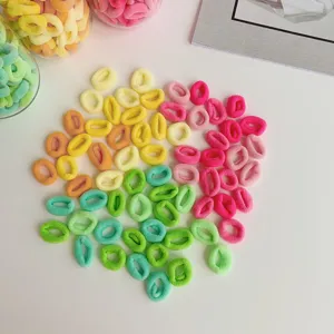 Detail of colorful elastic hair ties in macaron and milk tea shades on white surface.