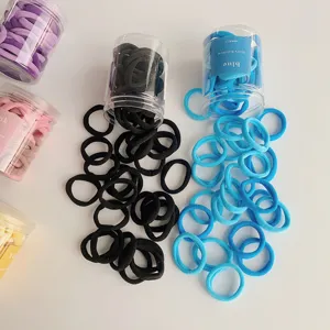Detailed shot of colorful elastic hair ties spilling from clear plastic storage jars