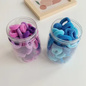 Premium elastic hair ties in pastel pink and blue shades presented in clear storage jars.