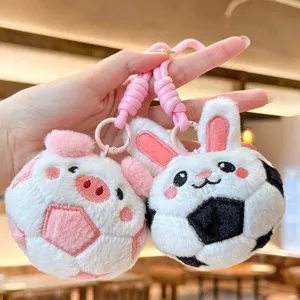 Close-up showing the soft texture and details of the pig and rabbit soccer plush keychains.