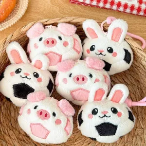 Detail view of cute cartoon plush pig and rabbit soccer keychains in a woven gift basket