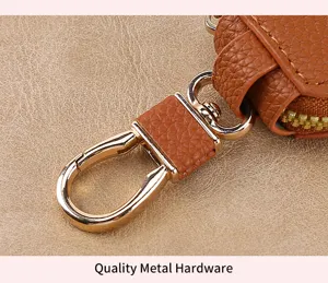 Detailed view of the premium brown leather car key pouch featuring polished gold metal hardware.