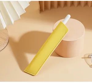 Nahaufnahme der minimalistischen gelben PU-Leder Stifttasche auf warmem Schreibtisch.