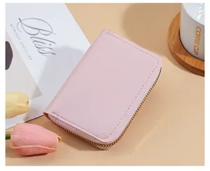Dettaglio del portacarte compatto in pelle rosa, con chiusura lampo liscia e scomparti multipli.