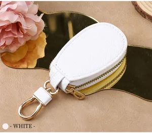 White leather car key case detail, compact mini key pouch with gold zipper and metal keychain hook.