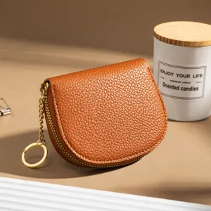 Brown leather half-round coin purse with zipper closure and key chain, stylish card holder.