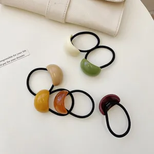 Macro view showing various minimalist colorful acrylic jelly hair ties on desk