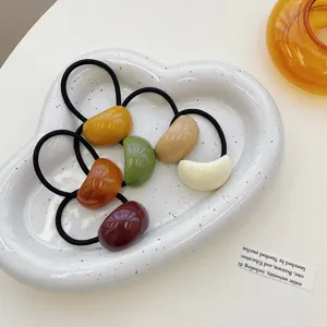 Macro shot of colorful jelly acrylic hair ties arranged in a white cloud-shaped tray.