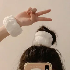 Vue détaillée de bracelets absorbants blancs et moelleux comme chouchou et protège-poignets.