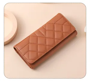 Close-up detail of the brown quilted trifold long wallet showing fine stitching and leather.