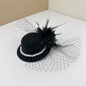 Detailed view of a vintage black fascinator hat with elegant mesh veil and pearls.