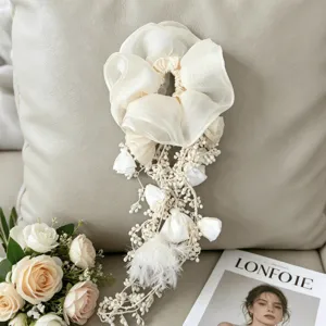 Detailed view of white organza scrunchie with bohemian floral tassels and feathers