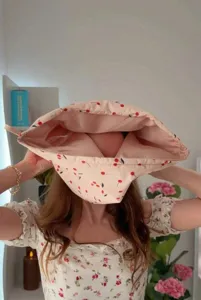 Detailed view of waterproof cherry print shower cap with pink lining