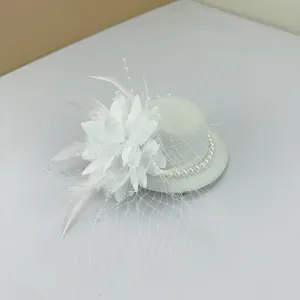 Detailed view of a vintage white fascinator hat clip with mesh veil and pearl accents