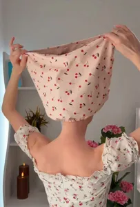 Back view of a woman wearing a waterproof pink shower cap with a cute cherry print