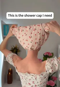Detail of waterproof shower cap with cherry pattern on a woman's head