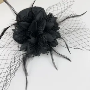 Κοντινή λεπτομέρεια ενός μαύρου vintage fascinator με φτερά, δαντέλα και μαύρο δίχτυ