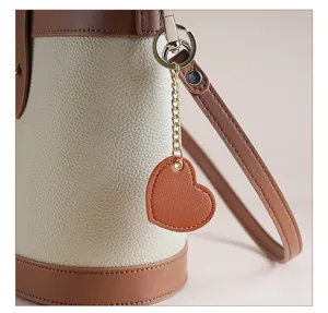Cute heart leather keychain pendant for handbags and car keys, stylish brown accessory charm.