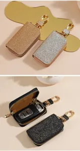 Dettaglio custodia per chiavi auto in pelle glitterata con zip e gancio in metallo.