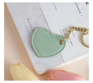 Green heart-shaped leather keychain with gold chain, cute bag and car key pendant accessory.