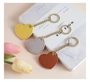 Heart-shaped leather keychain detail showing exquisite metal chain and smooth PU texture.