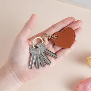 Cute heart leather keychain for car keys and bags, stylish metal hardware accessory.