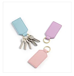 Close-up detail of square PU leather keychains in pastel colors with durable metal rings.