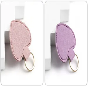 Leder Herz Schlüsselanhänger in Rosa und Lila mit goldenem Metallring, Detailansicht.