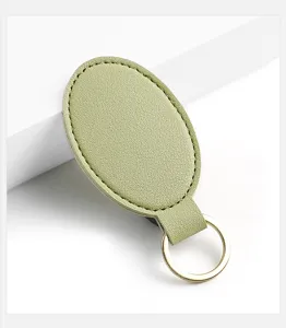 Llavero ovalado minimalista de cuero PU con anillo metálico dorado para organizar las llaves.