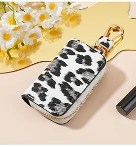 Pochette de clé de voiture en cuir léopard noir et blanc avec détails en métal doré