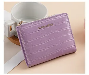 Portafoglio corto viola da donna con texture in pietra, cerniera e logo in metallo.
